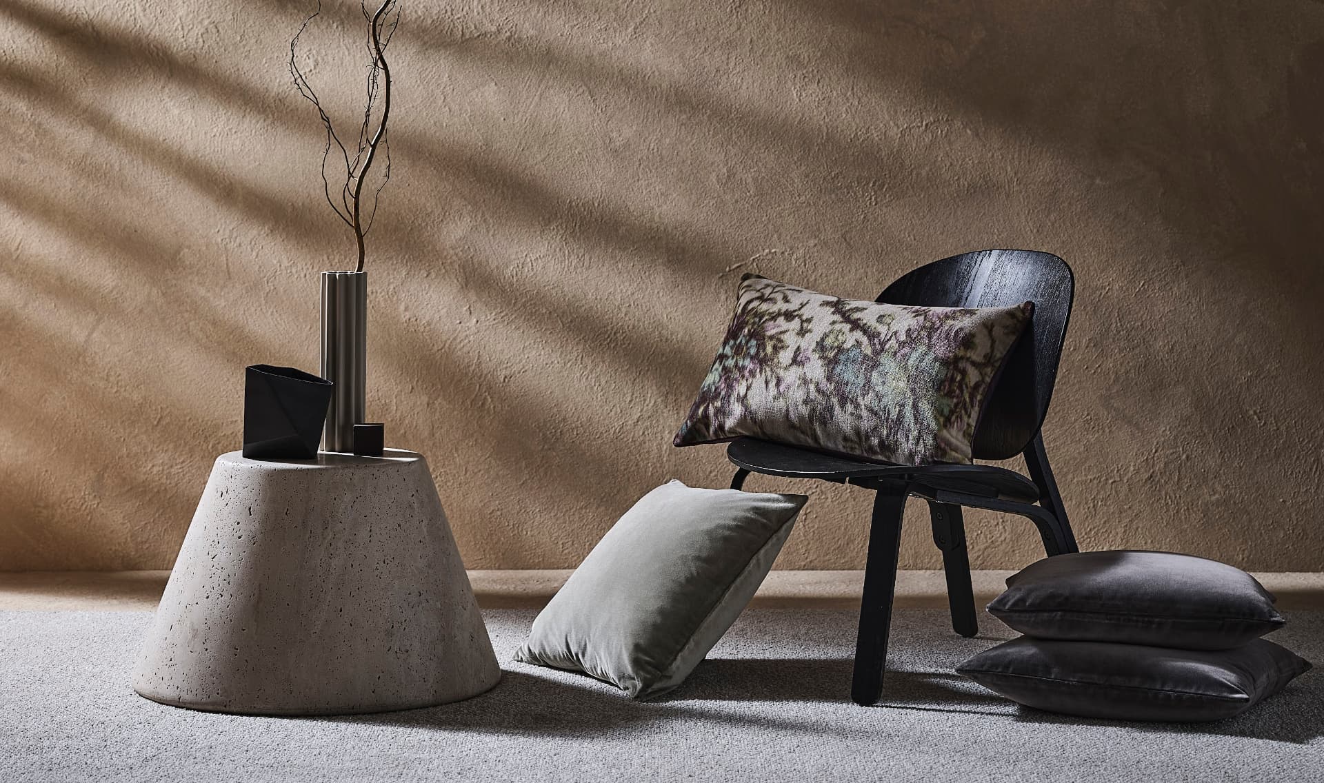 Sculptural travertine side table with cushions in a warm Milan interior by Studio IB Milano
